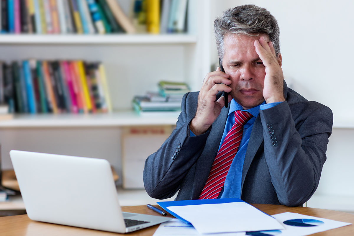 Unternehmer telefoniert mit seinem Anwalt, da er einen Bußgeldbescheid wegen unzureichenden Arbeitsschutzmaßnahmen erhielt.